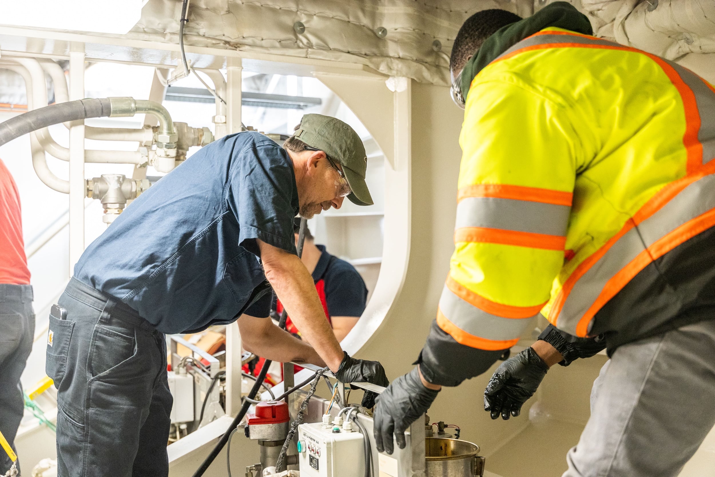 Team members servicing an oil purification unit for one of the vessel Thrusters. 
