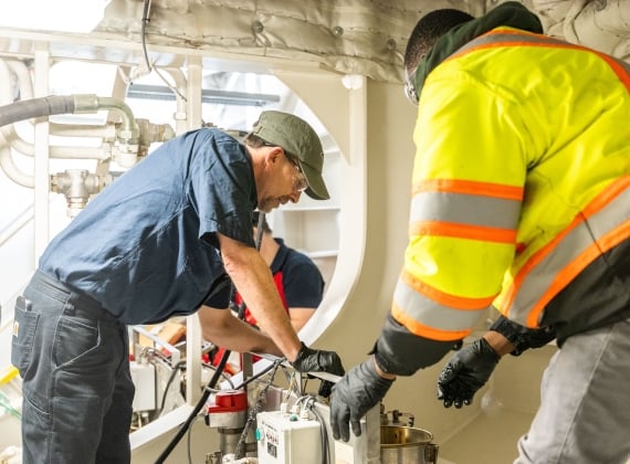 Team members servicing an oil purification unit for one of the vessel Thrusters. 