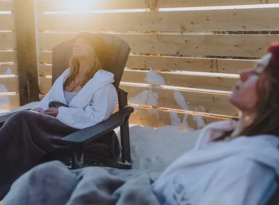 Two women relaxing at an outdoor spa in the evening sunshine.
