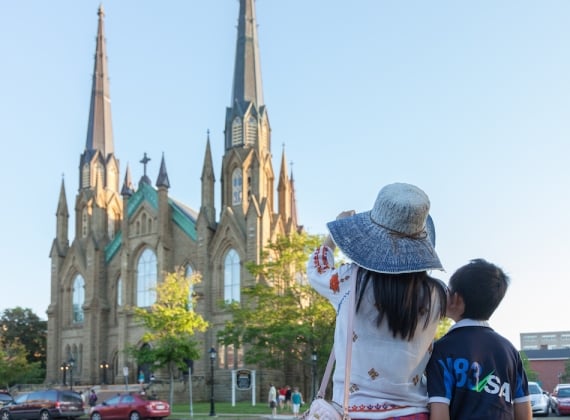 Two people facing a grand basilica on a sunny evening.