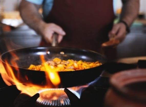 A frying pan over high heat on an open flame