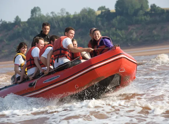 A full motor boat riding on a tidal bore