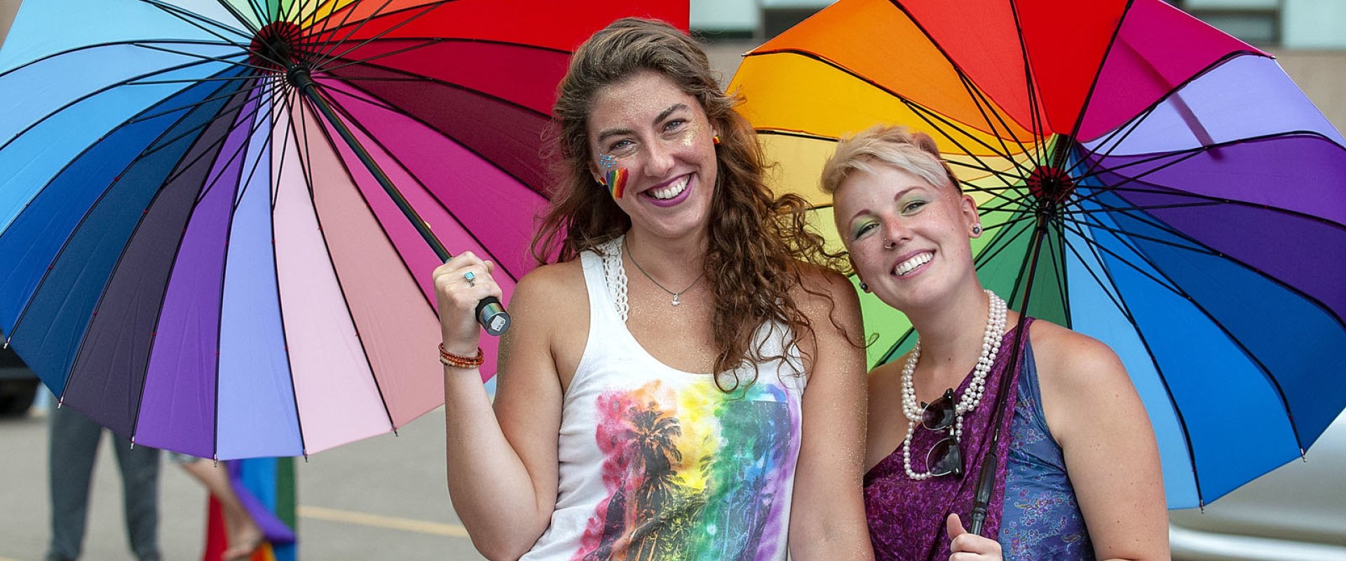 two-women-holding-rainbow-umbrellas