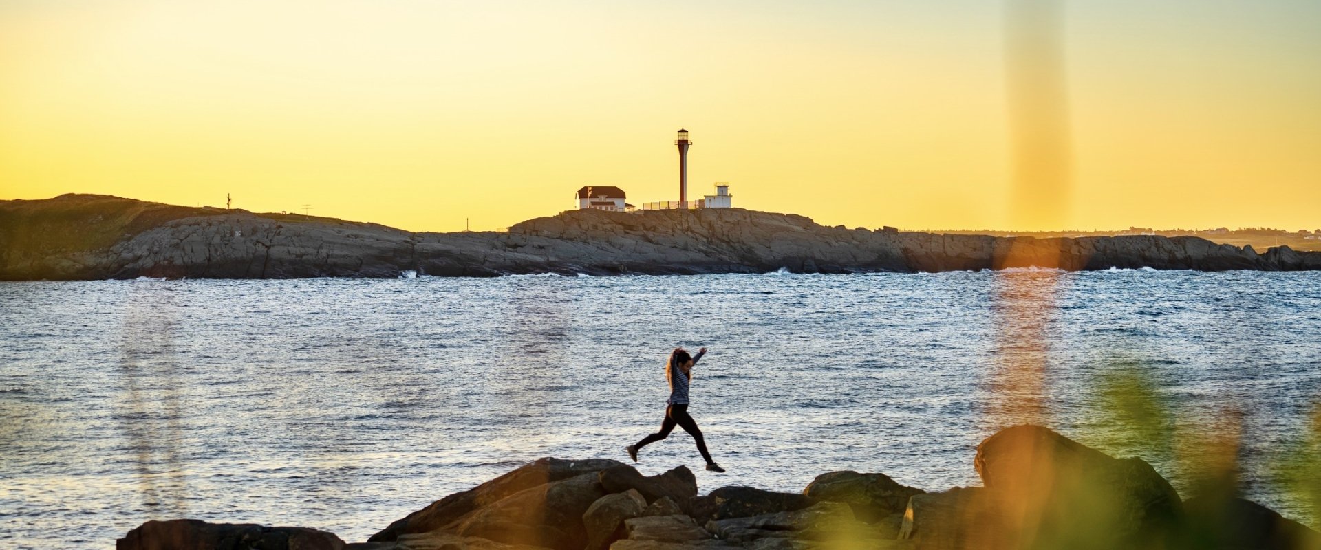 girl-jumping-off-rocks-at-cape-forchu-lighthouse